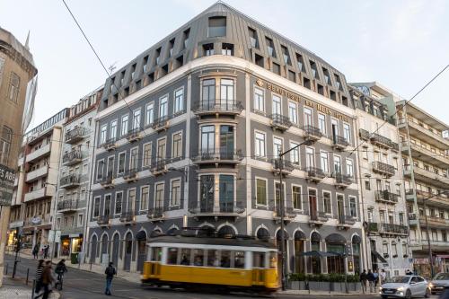 un bus jaune garé devant un bâtiment dans l'établissement Dos Reis by The Beautique Hotels, à Lisbonne