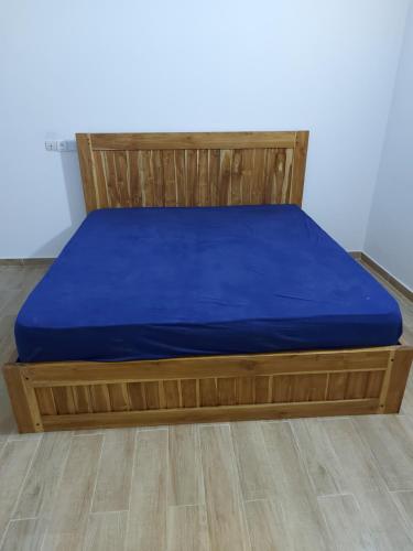 a bed with a blue bedsheet on top of it at Villa Eloy in Lomé
