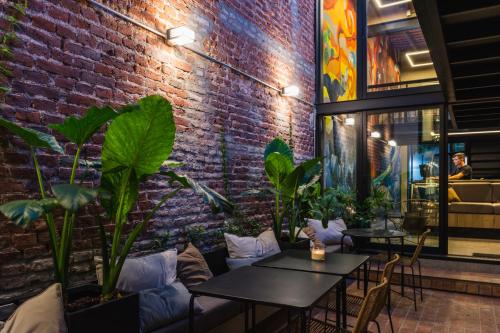een bakstenen muur met tafels en planten in een restaurant bij Faz Hostel in Cordoba