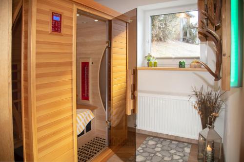 a walk in shower in a bathroom with wooden walls at Ferienhaus Hochvogel in Hinterhornbach
