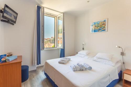 a bedroom with a bed and a large window at Apartment& Room Lukre / Apartment Lukre with terrace in Dubrovnik