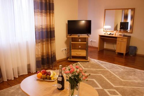 a living room with a table with a bowl of fruit at Starye Bendery in Bender
