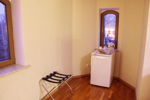 a room with a small refrigerator and a chair at Starye Bendery in Bender