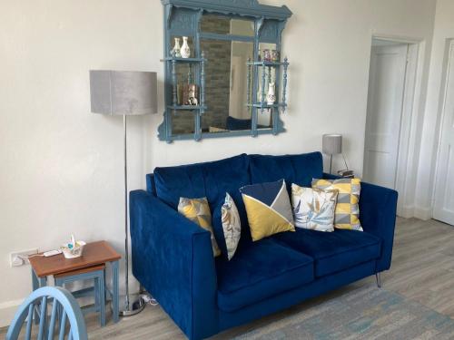 un sofá azul con almohadas en la sala de estar en Glenhill - Newly renovated in a unique location, en Belmullet