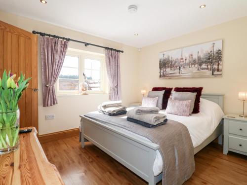 a bedroom with a large bed and a window at Little Gem in Uttoxeter