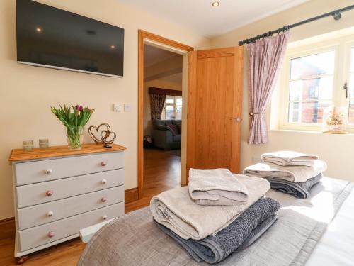 a bedroom with a bed and a dresser and a window at Little Gem in Uttoxeter