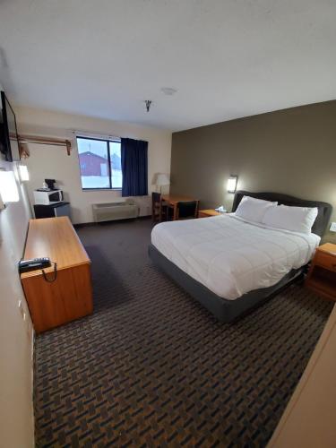 a hotel room with a bed and a desk at Hibbing Inn and Suites in Hibbing
