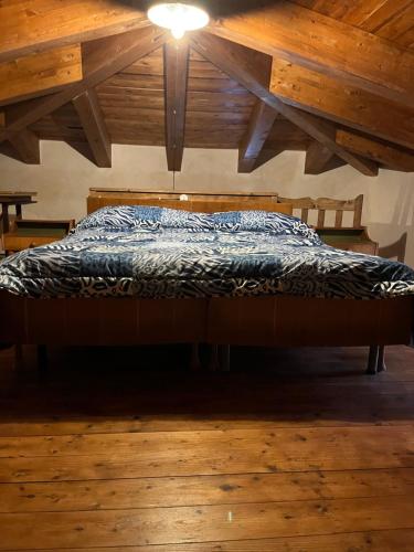 uma cama num quarto com pisos em madeira e um tecto em Il mulino ad acqua de Maffutiis em Auletta