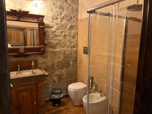 a bathroom with a toilet and a sink and a shower at Il mulino ad acqua de Maffutiis in Auletta
