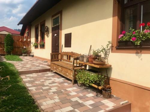 a patio of a house with a bench and plants at Chalupa u babky in Ružomberok