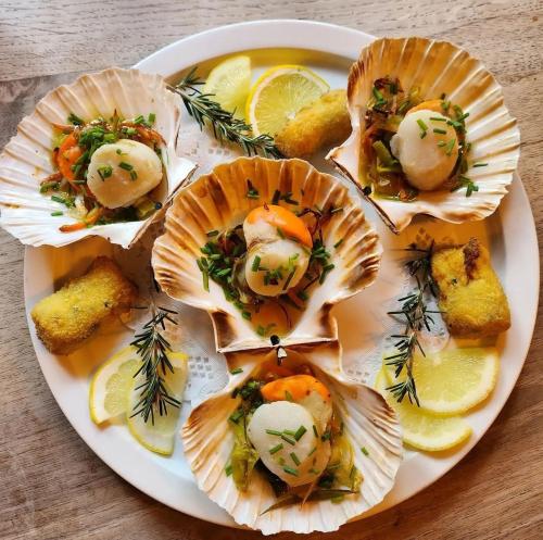 a white plate of food with oysters and lemon slices at Hotel restaurant La Pêcherie - Le manoir d'à coté - Les 5 ruches -Logis hôtels in Courseulles-sur-Mer