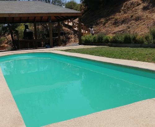 una piscina azul con cenador en lliulliunewen, en Limache