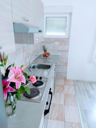 a kitchen with a stove and a vase of flowers at Holiday home Buljat in Kaštela