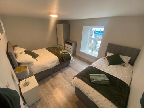 sypialnia z 2 łóżkami i oknem w obiekcie Baxters Apartments w mieście Milford