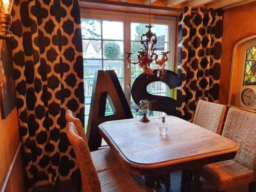 a dining room with a wooden table and a window at Hotel restaurant La Pêcherie - Le manoir d'à coté - Les 5 ruches -Logis hôtels in Courseulles-sur-Mer