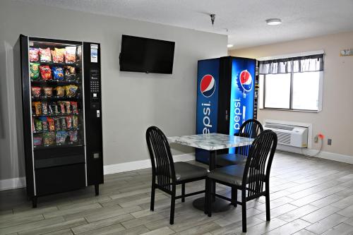 a dining room with a table and a soda refrigerator at Hibbing Inn and Suites in Hibbing