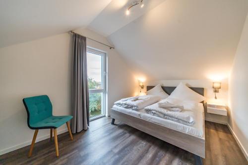 a bedroom with a bed and a chair and a window at Meerblick 43 in Wangerland