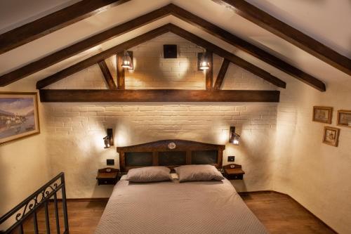 ein Schlafzimmer mit einem großen Bett in einer Ziegelwand in der Unterkunft Apartmani Sirmium in Sremska Mitrovica