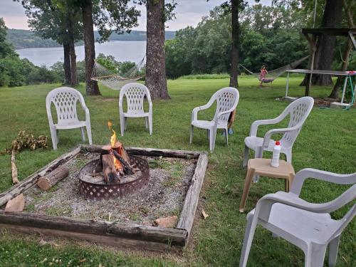 a group of white chairs around a fire pit at Wagon Wheel Resort Lake Norfork in Gamaliel
