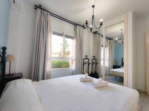 - une chambre avec un grand lit blanc et 2 serviettes dans l'établissement Laguna Beach Family - Alojamientos La Torre, à Torrox Costa