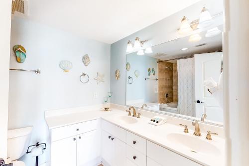 ein weißes Badezimmer mit zwei Waschbecken und einem großen Spiegel in der Unterkunft Caribbean Resort 1101 in Navarre