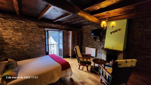 um quarto com uma cama, uma mesa e uma cadeira em Apartamentos Rurales Casa Ardaliz em Cangas del Narcea