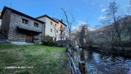 un edificio accanto a un fiume accanto a un edificio di Apartamentos Rurales Casa Ardaliz a Cangas del Narcea
