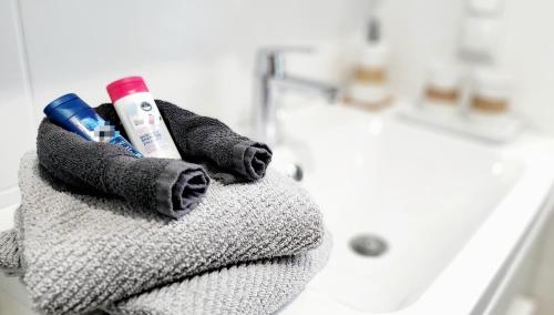 uma toalha com duas escovas de dentes e pasta de dentes ao lado de uma banheira em Ring Apartment am Nürburgring em Herresbach