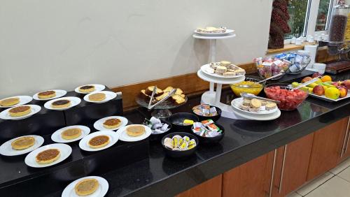 a buffet with many plates of food on a counter at Hotel Diego De Almagro Talca in Talca
