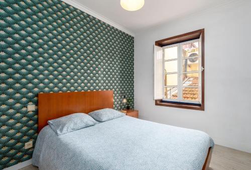 ein Schlafzimmer mit einem Bett und einer grünen Wand in der Unterkunft Renov Mar23 Clerigos Premium with self check in in Porto