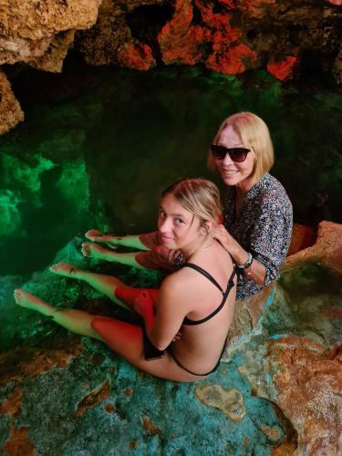 two women sitting in the water in a cave at Azcapri Villa Boutique & Spa in Cancún