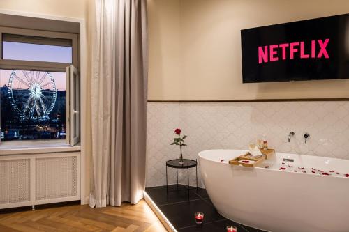 ein Badezimmer mit einer Badewanne und ein Fenster mit einem Riesenrad in der Unterkunft Budapest Eye- Boutique Suites, by BQA in Budapest