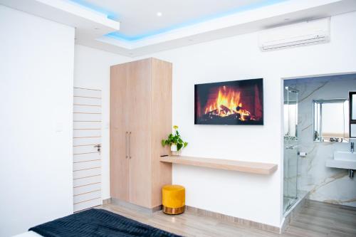 a living room with a fireplace and a tv on the wall at Golfview luxury apartment in Richards Bay