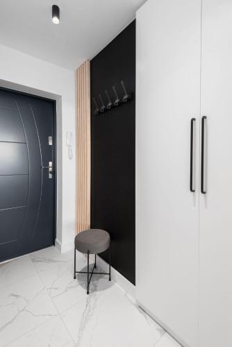 a black door with a black stool in a room at Kairos Apartments - Amber - darmowy Parking, ścisłe centrum in Gliwice