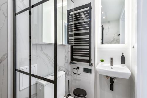 a bathroom with a sink and a toilet and a mirror at Apartament Amber - darmowy Parking, ścisłe centrum - by Kairos Apartments in Gliwice