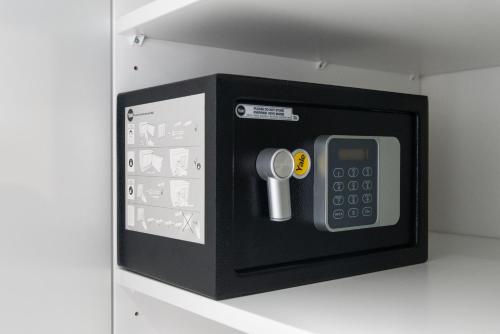 a black microwave with a remote control in it at Kairos Apartments - Amber - darmowy Parking, ścisłe centrum in Gliwice