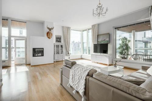 a living room with a couch and a tv at Spacious Home With four Terrace, Sauna, Sea View in Helsinki