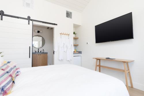 um quarto com uma cama e uma televisão na parede em The Pacific Motel em Cayucos
