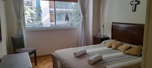 1 dormitorio con ventana grande y cama con almohadas en TORRE BARRANCAS DE BELGRANO en Buenos Aires