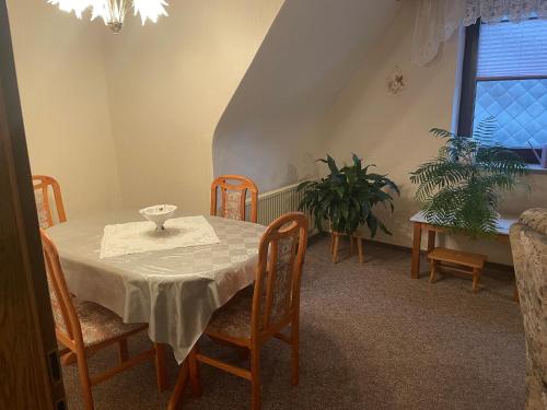 ein Esszimmer mit einem Tisch, Stühlen und einem Fenster in der Unterkunft Haus Wiesenblick in Walkenried