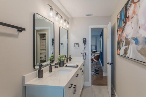 a bathroom with two sinks and two mirrors at Lake House Retreat Near Downtown, Disney, Universal Studios and Airport in Orlando