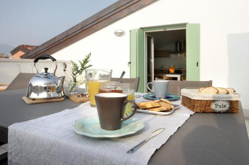a table with a cup of coffee and a basket of bread at Mariposa Apartments in Bardolino