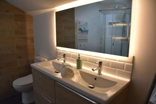 ein Bad mit einem Waschbecken und einem Spiegel in der Unterkunft [Le 8] Maison de ville élégante et tout confort in Saint-Martin-la-Rivière