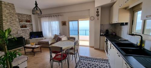 a kitchen and living room with a view of the ocean at Seaview Country House in Sarandë