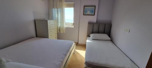 a small bedroom with two beds and a window at Seaview Country House in Sarandë