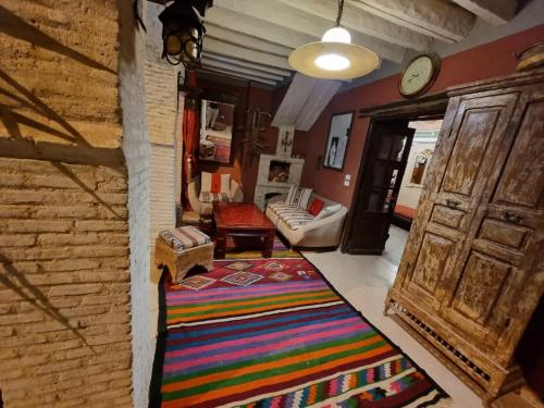 托澤爾的住宿－Dar El Sultan Tozeur，一间客厅,地板上铺着色彩缤纷的地毯