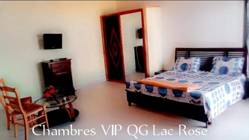 a bedroom with a bed and a table and a chair at Complexe le QG in Niaga