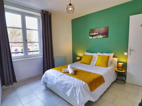 een slaapkamer met een groot bed met een groene muur bij T2 B and Wood "Cottage de Moissac" in Moissac