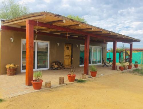 un pabellón con macetas delante de una casa en Refugio QueRet, en Palmilla