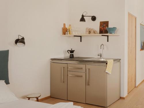 een kleine keuken met een wastafel en een aanrecht bij Urban Inn - Wilten 24/7 in Innsbruck